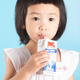 child drinking box of shelf stable milk with straw